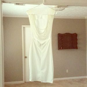 White dress with back draped with pearls.